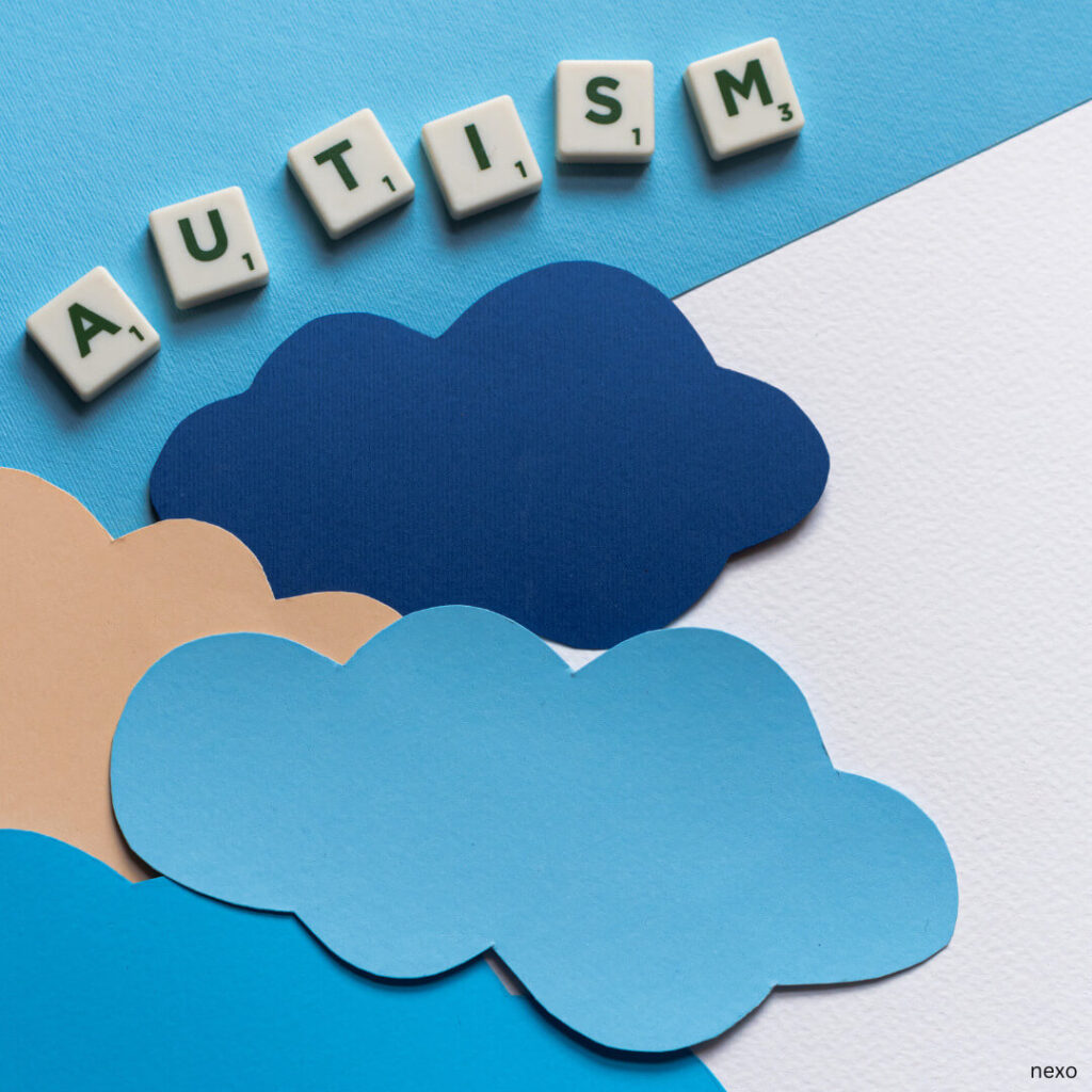 autism written with scrabble letters and some clouds in different shades of blue